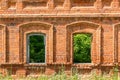 Two windows of the old destroyed building of red brick through w Royalty Free Stock Photo