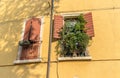 Two windows with open and closed shutters Royalty Free Stock Photo