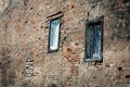 Two windows in red brick wall building in weird diagonal placement Royalty Free Stock Photo