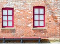 Two windows with red frames in a brick wall Royalty Free Stock Photo