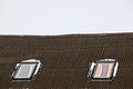 Two windows in the snow on a slate roof against the sky Royalty Free Stock Photo