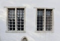 Two Windows on white wall with metal protection medieval old house Royalty Free Stock Photo