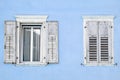 Two windows with window shutters in a blue house Royalty Free Stock Photo