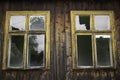 Two windows with yellow frames and broken glass Royalty Free Stock Photo