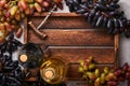 Two Wine bottles with grapes and wineglasses on old gray concrete table background with copy space. Red wine with a vine branch. W Royalty Free Stock Photo