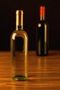 Two wine bottles on wooden table and black background Royalty Free Stock Photo