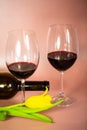 Two wine glasses with wine bottle, pink background