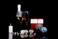 Two wine glasses with champagne, Christmas ornaments, gift box and candle on a black background Royalty Free Stock Photo