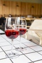 Two wine glasses filled with red wine, served on a white table in restaurant or bar. Royalty Free Stock Photo