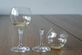 Two wine glasses. One half full broken glass and another half full undamaged wine glass on wooden table