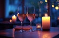 two wine glasses waiting near candles next to two candlesticks on a table