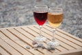 Two wineglass with red, white wine stand on table near in afternoon Royalty Free Stock Photo