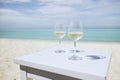 Two wineglass with white wine on table against beach Royalty Free Stock Photo