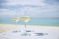 Two wineglass with white wine on table against beach Royalty Free Stock Photo