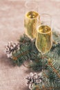 Two wineglasses of champagne with Christmas tree branches