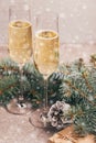 Two wineglasses of champagne with Christmas tree branches