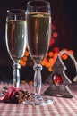 Two wineglasses of champagne and new year`s decoration and cinnamon on the bokeh background