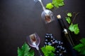 Two wineglasses with red wine, bottle and grape leaves lying on dark wooden background. Royalty Free Stock Photo