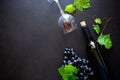 Two wineglasses with red wine, bottle and grape leaves lying on dark wooden background. Royalty Free Stock Photo