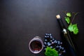 Two wineglasses with red wine, bottle and grape leaves lying on dark wooden background. Royalty Free Stock Photo