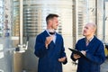 Two winemakers checking up wine sample in glass. Royalty Free Stock Photo