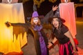 Two witches with scary face paint make up during Halloween party at the artificial cemetery on the beach