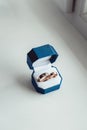 Two wite wedding rings in blue box on a white window sill