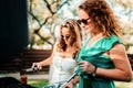 Two woman cooking at barbecue party, having drinks and smiling Royalty Free Stock Photo