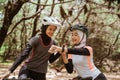 Two woman cycling and her friend looking at the watch Royalty Free Stock Photo