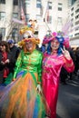 Two woman in elaborate costumes, hat and wigs pose for pictures during Easter Bonnet Parade.