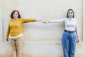 Two women with face masks representing social distancing