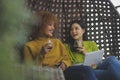 Two woman gossiping in the swing. Lesbian couple relaxing and drinking red wine. Close up Royalty Free Stock Photo