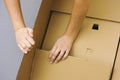 Two woman hands opening big cardboard box Royalty Free Stock Photo