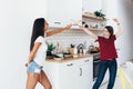 Two woman image that they are fighting on swords by wooden spatulas in kitchen