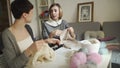 Two woman knitter talking and smiling in sewing studio. Woman knitting wool