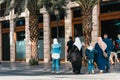 Two woman in Muslim long clothes and hijabs and a young girl in modern clothes and hidjab