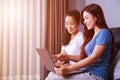 Two woman using a laptop computer on sofa in living room at home Royalty Free Stock Photo