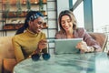 Woman using tablet and credit card together inside cafe