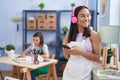 Two women artists drawing on notebook listening to music at art studio