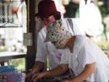 Two women Asian wear fabric face mask standing to select buy product at shop in market