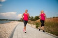 Two women athlets running on the beach - early morning summer w Royalty Free Stock Photo