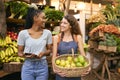 Two Women With Basket Of Lemons And Digital Tablet Working At Fruit And Vegetable Stall In Market