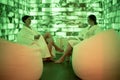 Two women in bathrobe sitting and relaxing in salt room Royalty Free Stock Photo