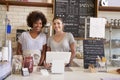 Two women behind the counter at a coffee shop, close up