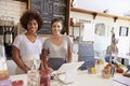 Two women behind the counter at a coffee shop, wide angle