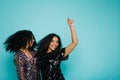 Two women with black curly hair dancing in studio