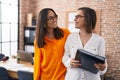 Two women business workers holding binder at office