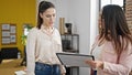 Two women business workers reading document standing at office Royalty Free Stock Photo