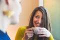 Two women in a cafe smiling and looking each other Royalty Free Stock Photo