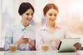 Two Women in Cafeteria with Coffe and Tablet. Royalty Free Stock Photo